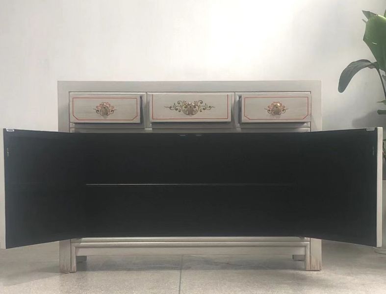 Breites Sideboard mit drei Schubladen und geöffneten Türen – Innenraum dunkel gehalten, Außenbemalung mit floralen Elementen.