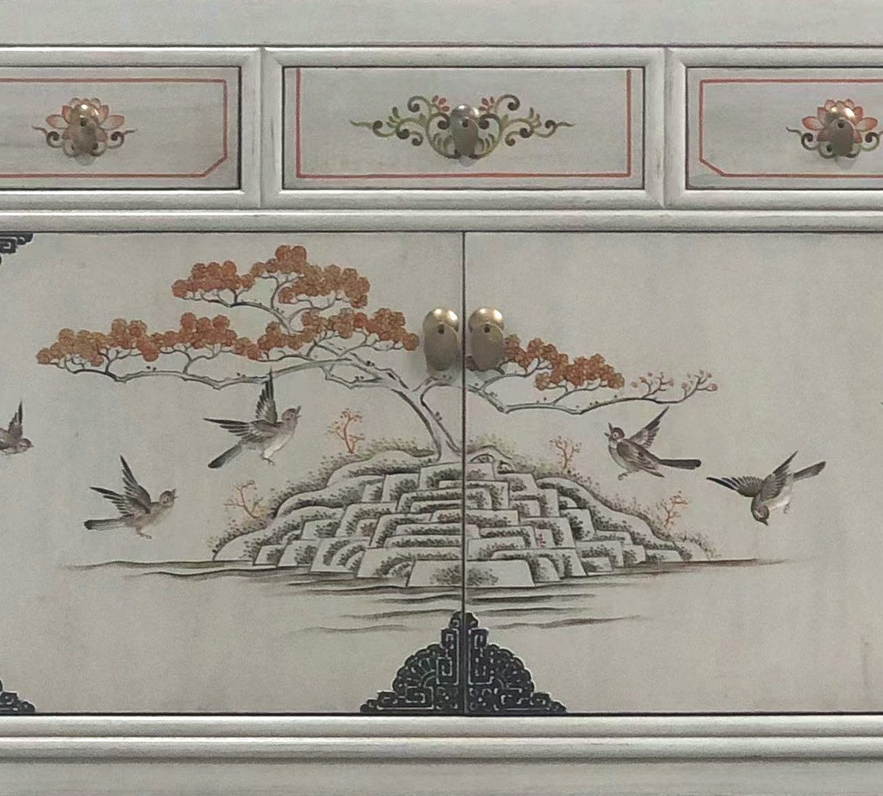 Detailaufnahme der Türen einer Vintage-Kommode mit asiatischer Malerei: Vögel fliegen über einem stilisierten Baum und Terrassenhügeln.