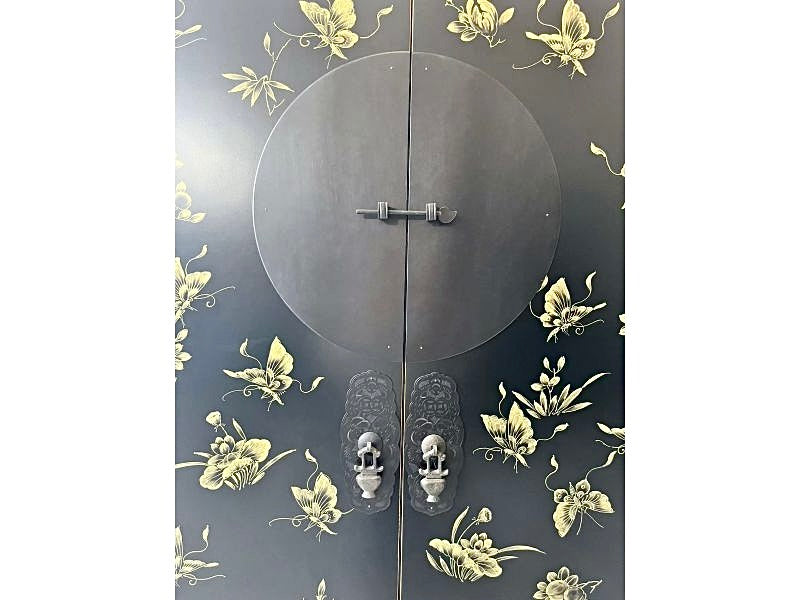 Detailansicht der antik wirkenden Türbeschläge an einem schwarz-gelben Schrank im asiatischen Stil.