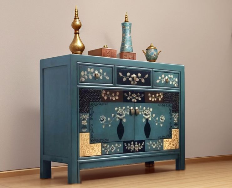 Kommode im orientalischen Stil mit petrolfarbener Bemalung und floralem Vasenmotiv, dekoriert mit orientalischen Accessoires in Wohnumgebung.