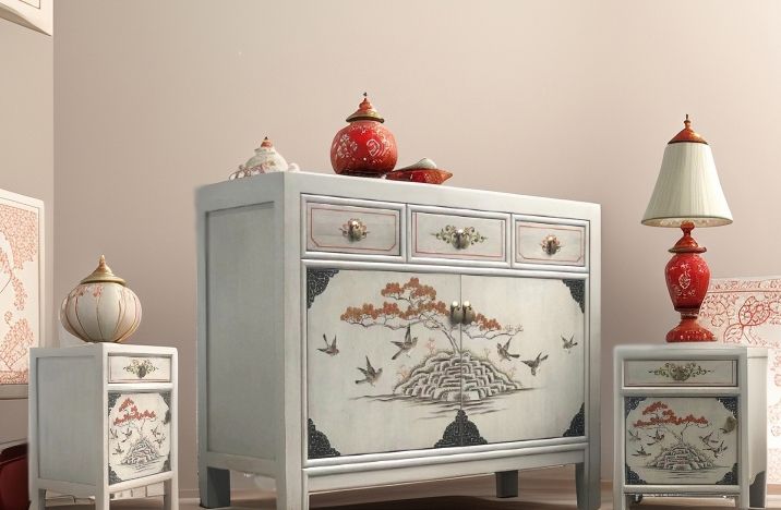 Interieurszene mit Sideboard und zwei passenden Nachttischen, asiatisch bemalt, umgeben von roten Keramikelementen und Lampen.