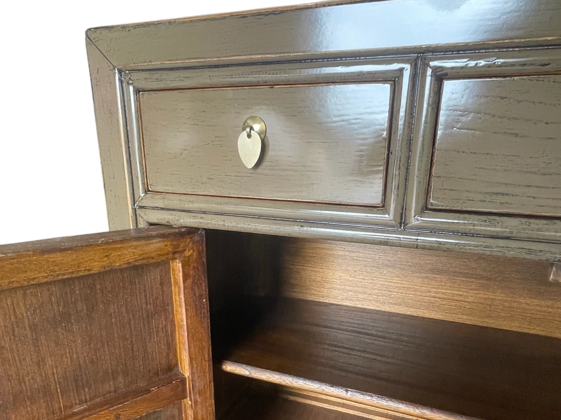 Nahaufnahme der oberen Schublade und geöffneten Tür des braun-beigen Sideboards, sichtbares Holzinnere.