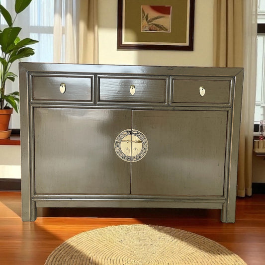 Braunes Sideboard in heller Wohnumgebung, umgeben von Pflanzen und warmem Lichteinfall.