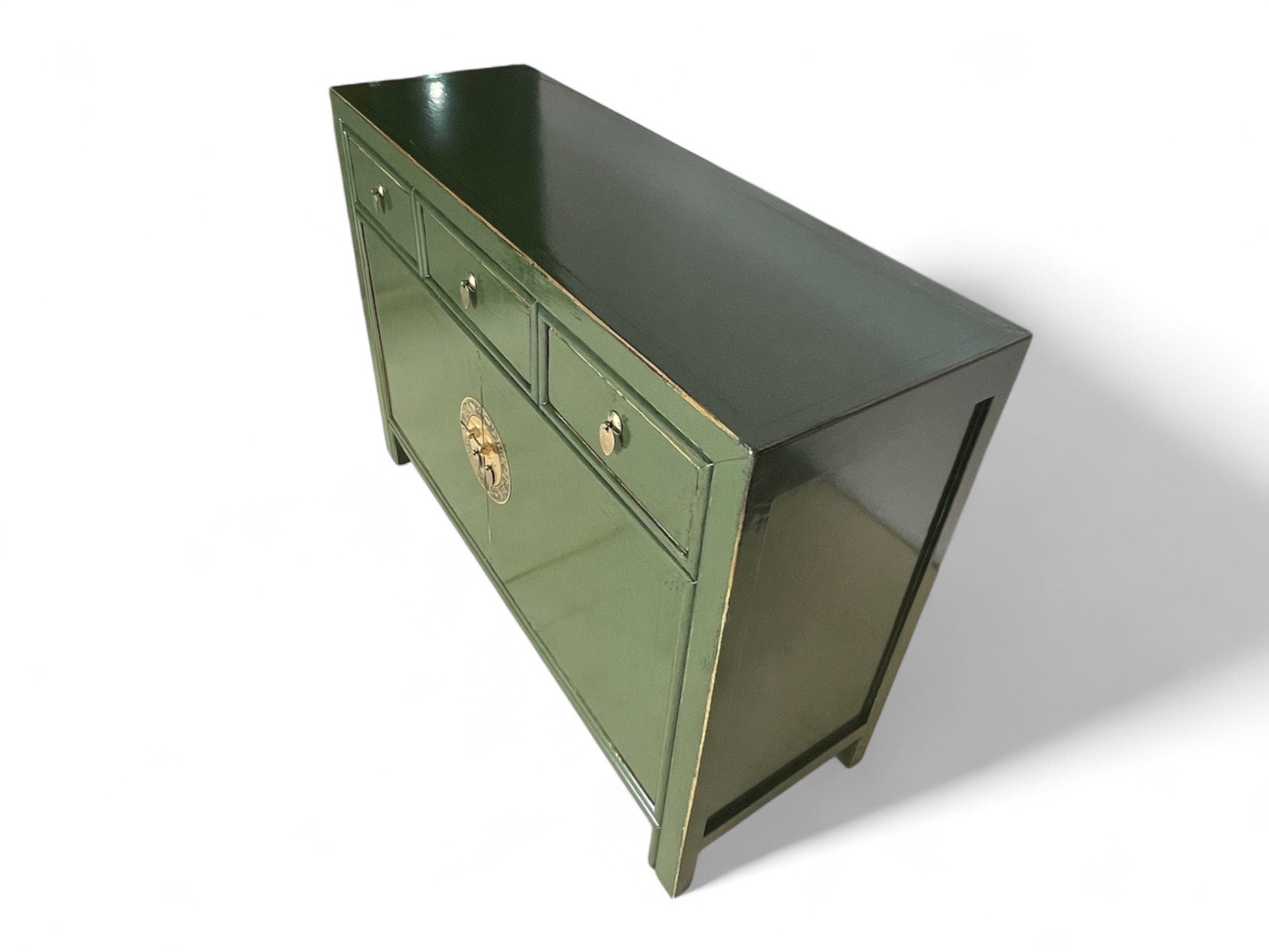 Grüne Vintage-Kommode mit glänzender Oberfläche, schräg von oben fotografiert, betont elegante Linienführung und Lackierung.